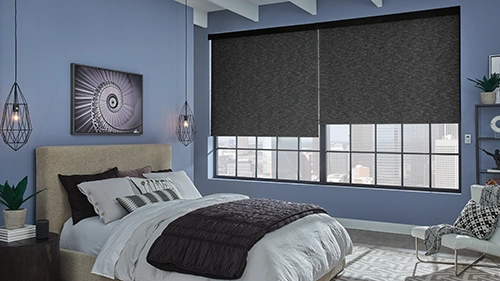 Dark gray motorized shades in two large windows inside of a urban like bedroom
