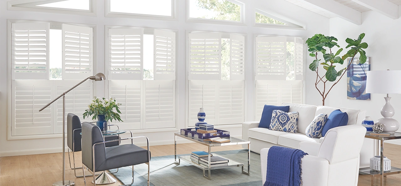 White shutters in cafe style within a large white room with blue decor