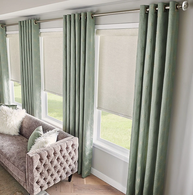 Sage green draperies over 3 large and tall windows in a living room
