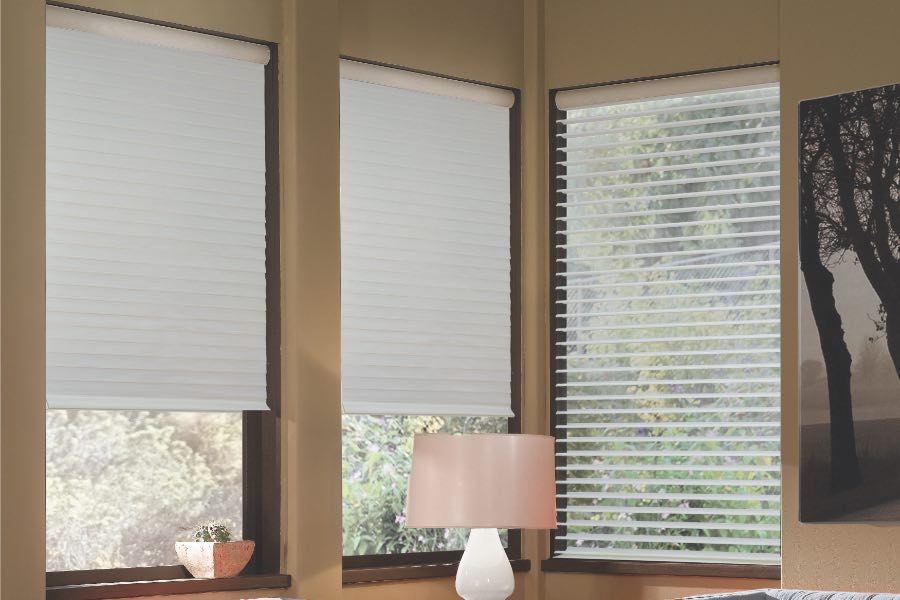 Opaque motorized window shades in Indianapolis keep hot UV rays out of your home. Gray motorized sheer shades on corner windows next to gray furniture