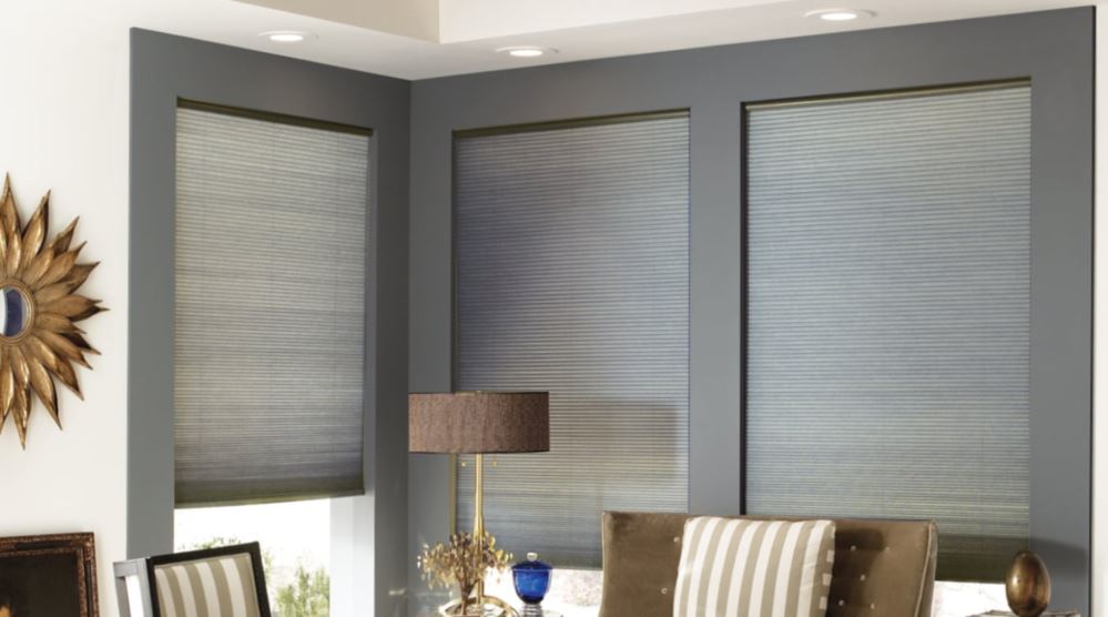 Custom cellular shades come in many fabrics and colors. Gray cellular shades in a window