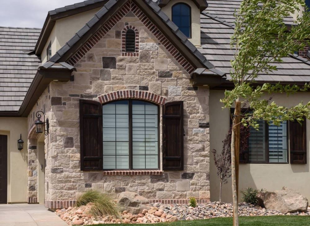 Put your tax refund to good use and make repairs or updates to your roof, windows, or landscaping. White interior shutters showing through two windows on the front of an attractive house