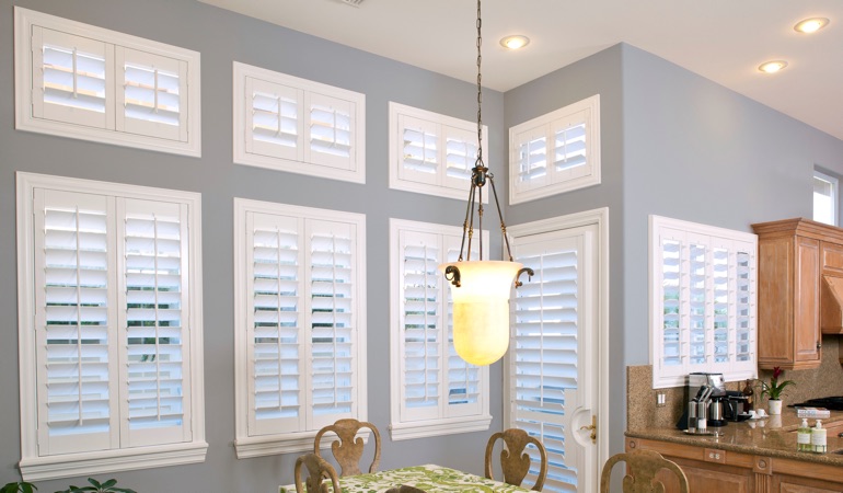 Interior Shutters can fix both sun glare and energy efficiency problems. White plantation shutters in kitchen