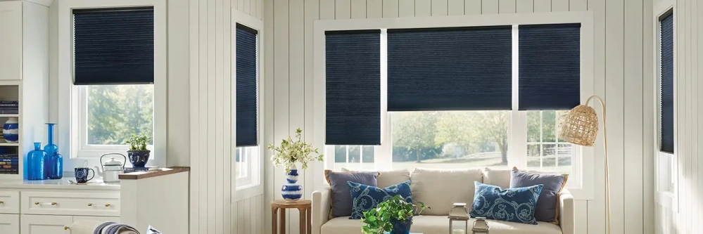 Navy blue cellular shades on windows in a white sitting area