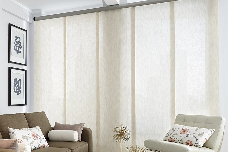 Find window treatments to complete any interior design among our extensive selection at Sunburst Shutters Indianapolis.  Long off-white window shades on a tall window in a modern living room