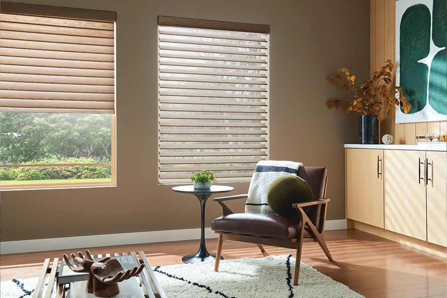 Sheer shades combine the softness of fabric shades with the light control of interior shutters for beauty and functionality. Tan sheer shades on living room windows