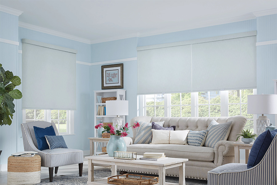 Available in many different materials, colors, patterns, and opacities, roller shades work for various living spaces. Large custom roller shades on living room windows