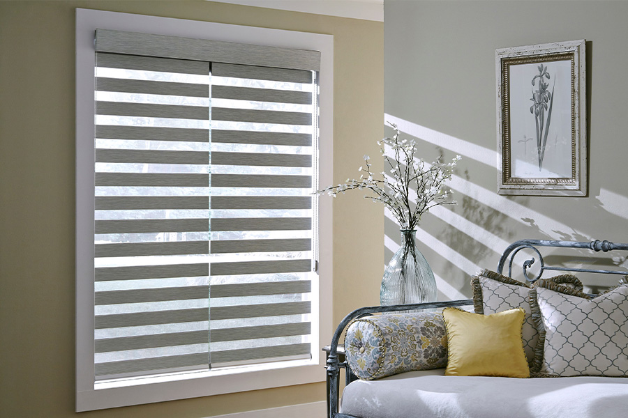 Find Versatile and stylish window blinds for Indianapolis homes at Sunburst. Gray blinds on a large window next to a couch.
