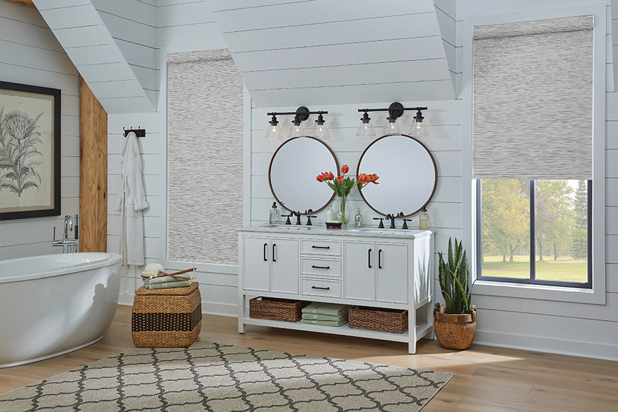 Slim-profile roller shades easily fit shallow windows in your Indianapolis home. Gray patterned roller shades on bathroom windows